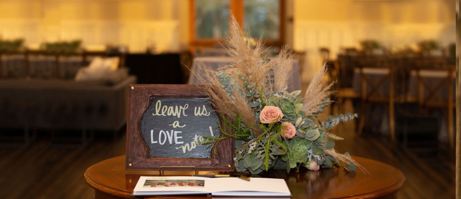 Table with flowers and a sign that says leave us a love note