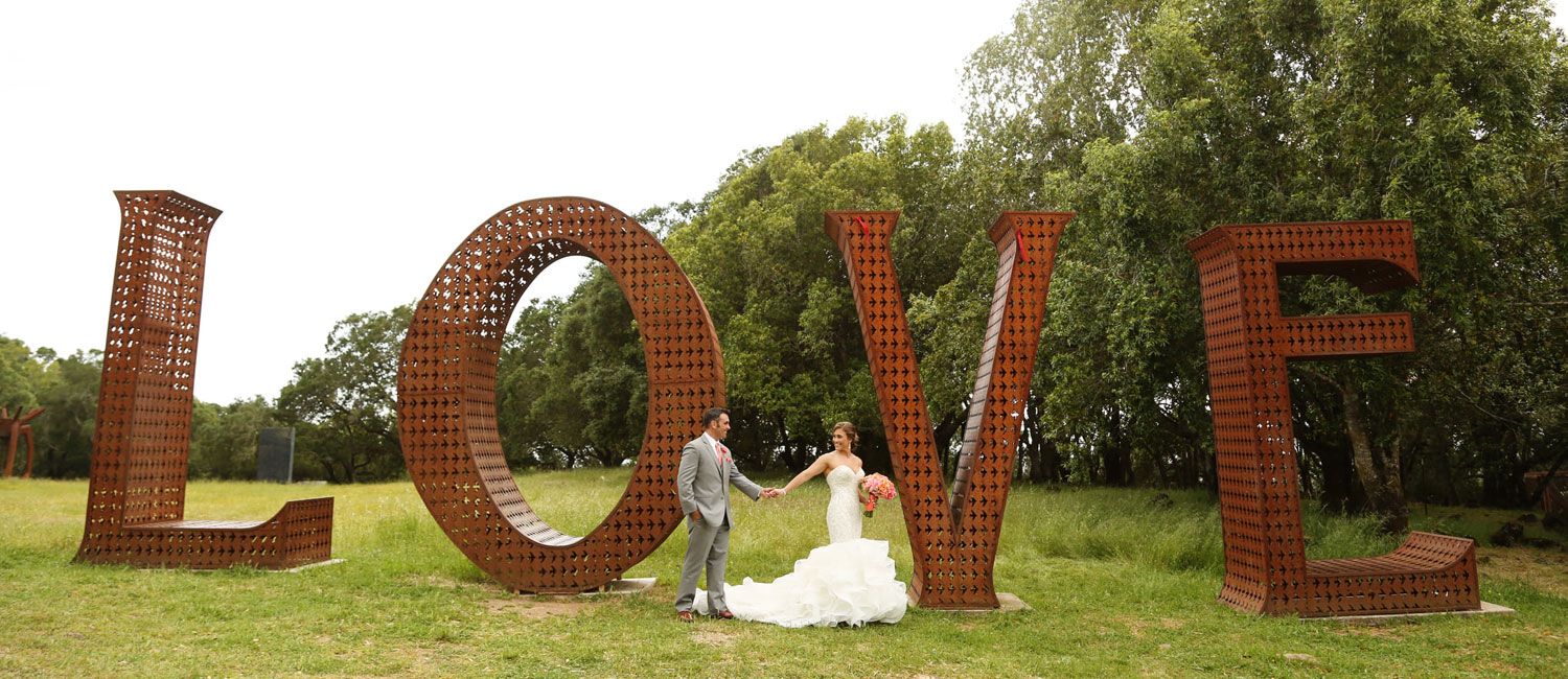 Bride and groom holding hands in front of the LOVE sculpture